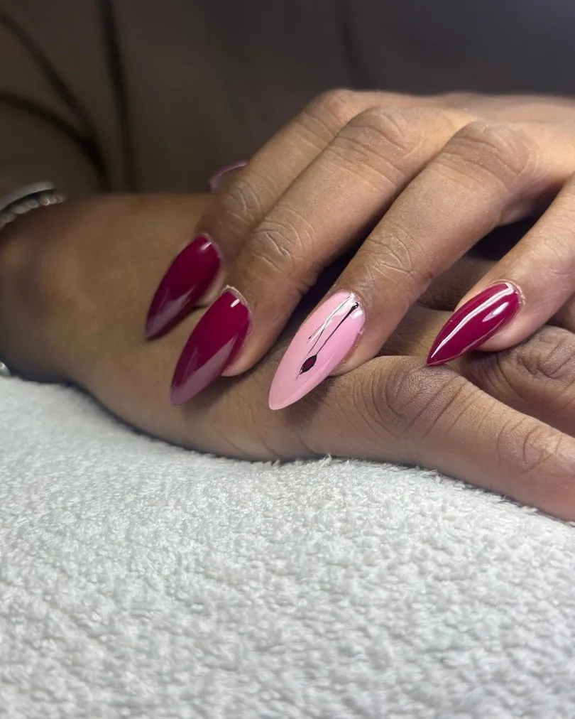 Ongles bordeaux et rose poudré en amande, mains croisées sur un linge blanc
